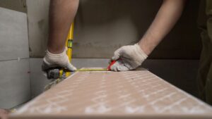 craftsman measuring bathroom tiles